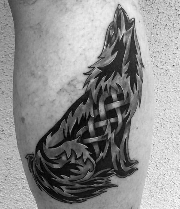 Howling Celtic wolf tattoo with sharp-edged fur details and interwoven knotwork pattern across the body, placed on the outer calf.
