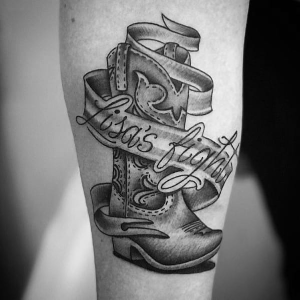 Cowboy boot tattoo with a ribbon wrapped around it, featuring the words "Lisa's Fight," symbolizing resilience and personal struggle.