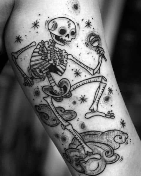 Dancing skeleton tattoo with a lively pose, wearing a hat and holding a maraca, surrounded by stars and clouds for a bold look.