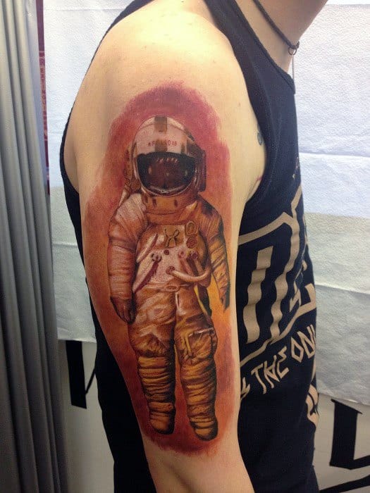 Astronaut tattoo design inspired by Deja Entendu album, showing a floating space suit with a red-orange background on upper arm