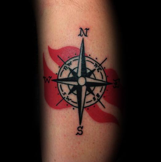 Tattoo of a detailed compass rose over a flowing red and white dive flag, symbolizing direction, adventure, and a passion for ocean exploration.