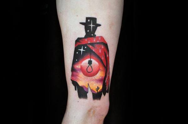 Silhouette of a cowboy with a sunset desert scene inside, featuring a noose, stars, cacti, and a dramatic sky in vibrant colors.