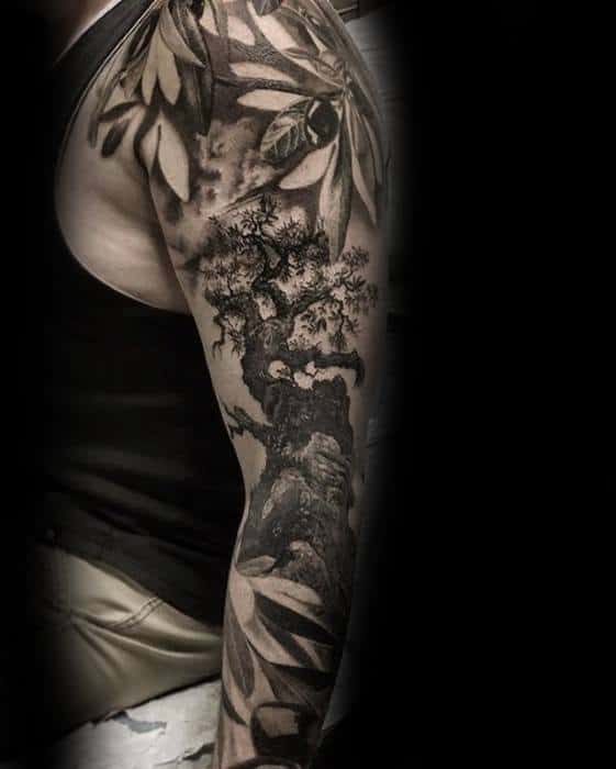 Tattoo of a bonsai tree and leaves on an upper arm and shoulder