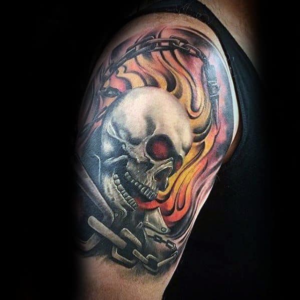 Ghost Rider tattoo on upper arm featuring a flaming skull, chains, and intense fiery background in bold, vivid colors.