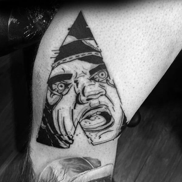 Glitch-style tattoo of a screaming face inside a bold letter A shape, with intense expression and dramatic black ink lines