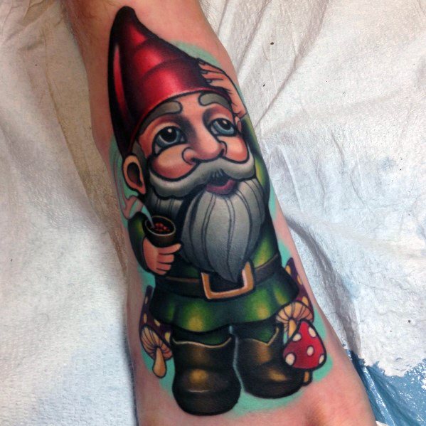Cartoon-style gnome tattoo with a red hat, gray beard, and green outfit, holding a pipe, surrounded by mushrooms on a blue background.
