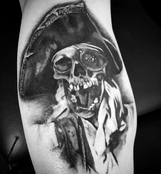 Black and gray tattoo of One-Eyed Willy from The Goonies featuring a detailed skull wearing a pirate hat and tattered clothing.