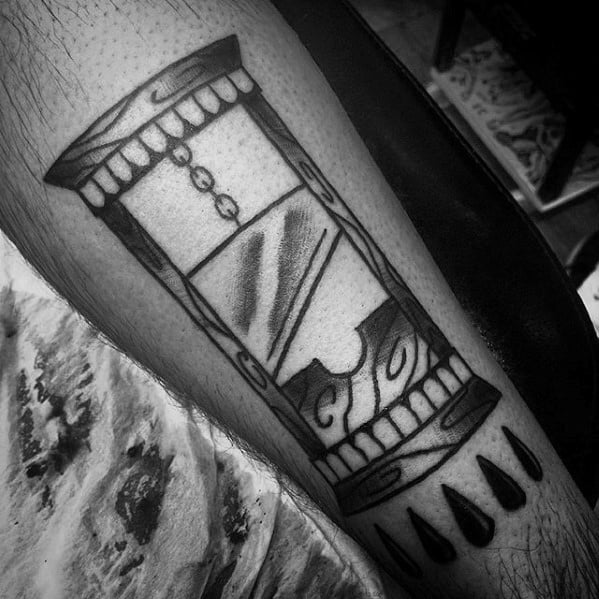 Black ink guillotine tattoo with stylized hourglass design, chains, wood texture, and teardrop shapes at the bottom.