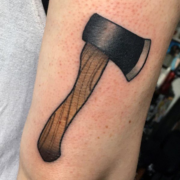 Hatchet tattoo with a bold black blade and a wooden-textured handle, designed with shading for a three-dimensional effect on the arm.