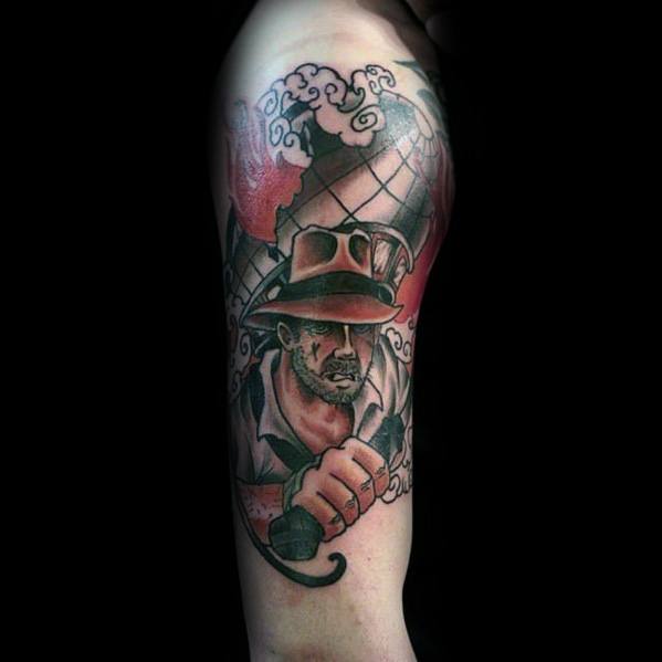 Indiana Jones tattoo featuring the adventurer in his iconic hat, gripping a whip, with a globe and clouds in the background.