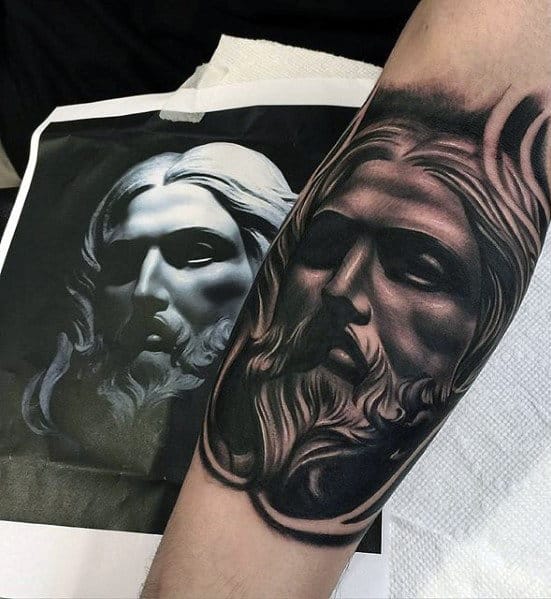 Forearm tattoo depicting a bearded man's face, alongside the reference image