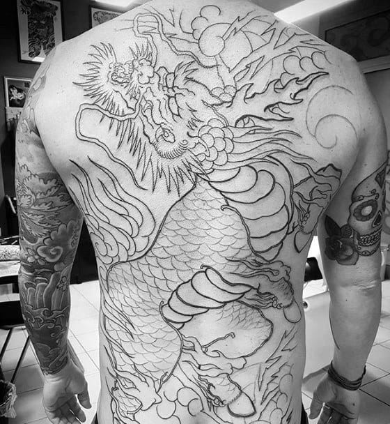 Kirin tattoo outline on man's back featuring bold, mythic dragon-like creature with intricate scales and dynamic movement.