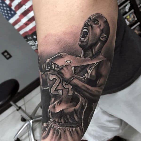 A detailed tattoo of Kobe Bryant in his iconic pose, wearing his Lakers jersey, passionately celebrating with his number 24.