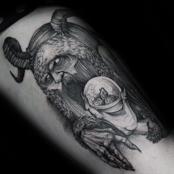 Krampus tattoo featuring a horned, bearded creature holding a snow globe with a house inside, done in dark, detailed black ink.
