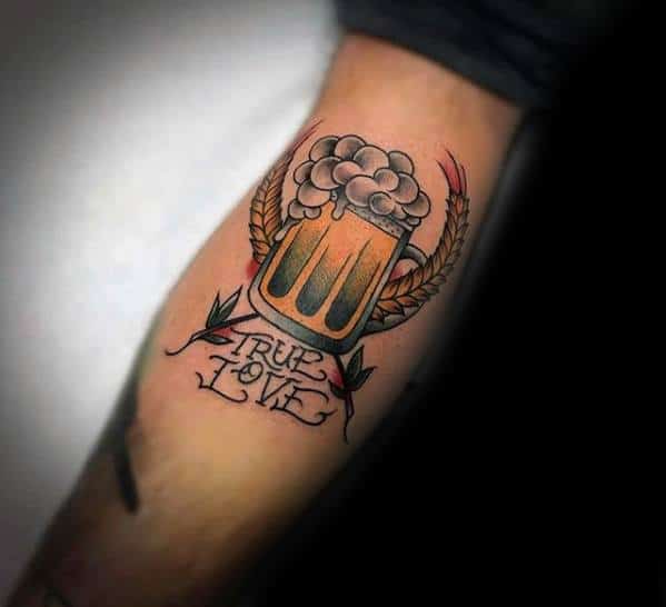 Traditional-style tattoo of a foaming beer mug flanked by barley stalks and leaves, with the phrase "True Love" inked below in elegant script.