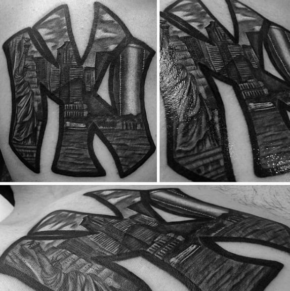 Black and gray tattoo of the New York Yankees logo filled with detailed NYC skyline elements, including skyscrapers and the Statue of Liberty.