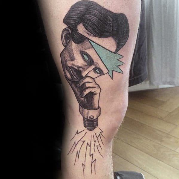 Tattoo of Nikola Tesla with a geometric headband, glowing eyes, and a lightbulb base emitting electricity from his chin.