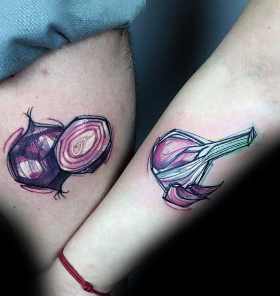 Matching onion tattoos on forearms with a watercolor-style design, featuring a sliced red onion and a whole onion with sprouting leaves.