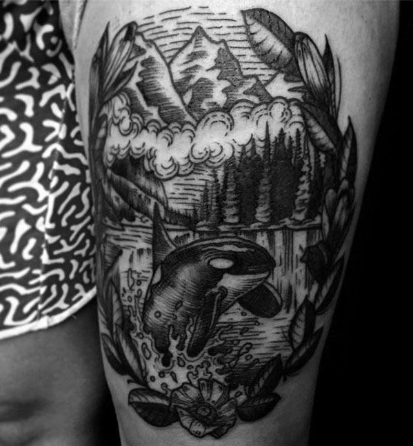 Black and gray orca tattoo on the upper arm, surrounded by a scenic landscape of mountains, trees, and clouds, with floral elements framing the scene for a harmonious, natural look.
