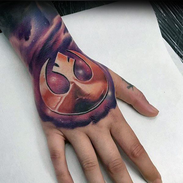 Person's hand with a colorful Rebellion symbol tattoo from Star Wars on the back of the hand