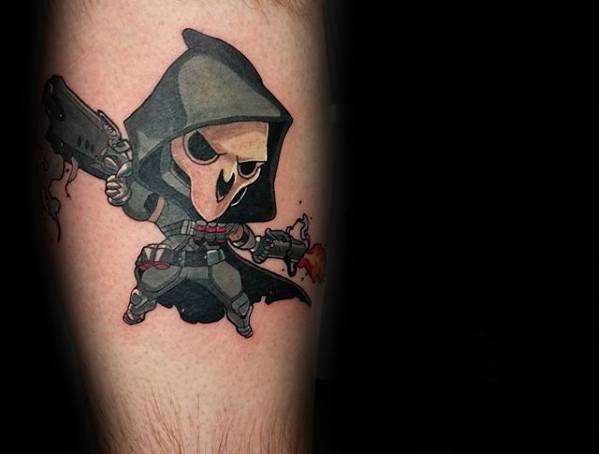 Cartoon-style Reaper from Overwatch tattoo with dual guns and a hooded cloak, inked in bold colors on a man's leg