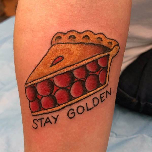 Cherry pie tattoo with golden crust and the words Stay Golden, symbolizing nostalgia, warmth, and a love for classic desserts