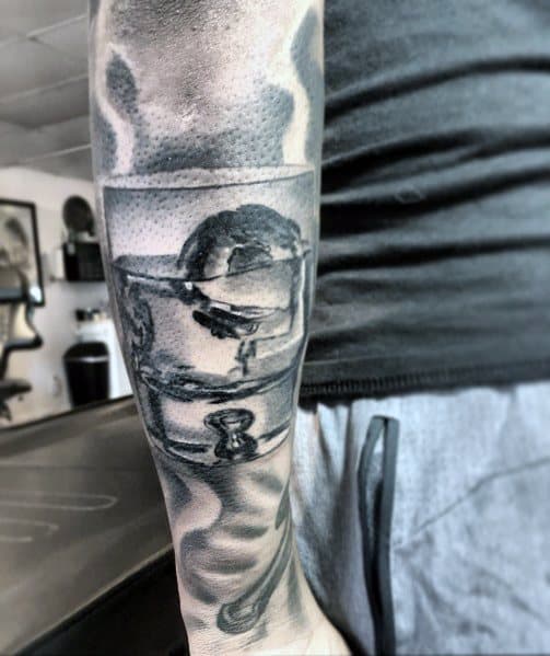Shot glass tattoo with realistic shading on the forearm, featuring reflections and a skull inside the glass for a bold, edgy look.