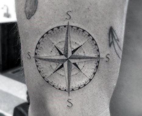 Detailed compass tattoo with fine dotwork shading and bold lines, symbolizing navigation, exploration, and personal direction.