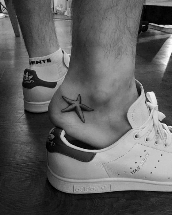 Simple black starfish tattoo on the inner ankle, positioned above the heel and visible with low-cut sneakers.