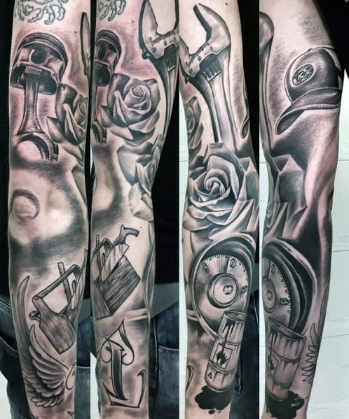 Black and grey Subaru-themed sleeve tattoo featuring pistons, wrenches, roses, and a gauge, blending mechanical and artistic elements.