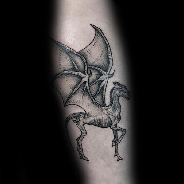 Thestral tattoo featuring a skeletal, winged horse-like creature with detailed shading on the forearm.