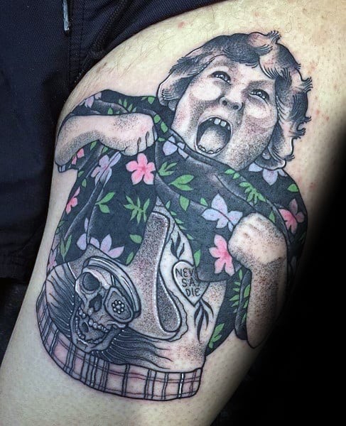 Tattoo of Chunk from The Goonies doing the Truffle Shuffle, revealing a skull tattoo with the phrase "Never Say Die" on his stomach.