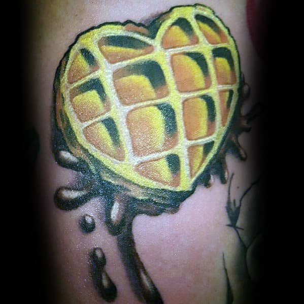 Heart-shaped waffle tattoo with realistic shading, golden brown tones, and syrup splashes for a bold and creative food-inspired design.