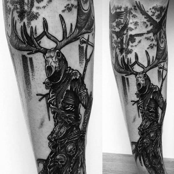Dark and detailed Witcher tattoo featuring a forest creature with antlers, skulls, and bones on a man’s forearm in black ink.