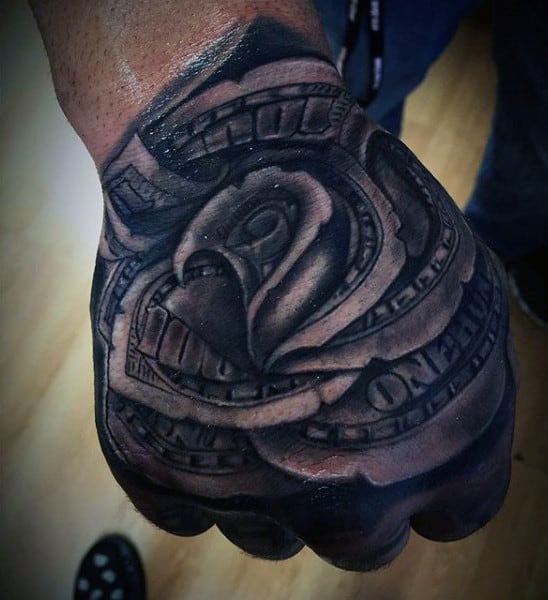 Tattoo of a rose made from folded dollar bills on a hand