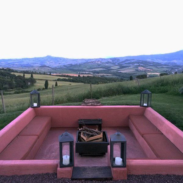 Sunken pink seating area with fire pit, lanterns, and scenic countryside views.