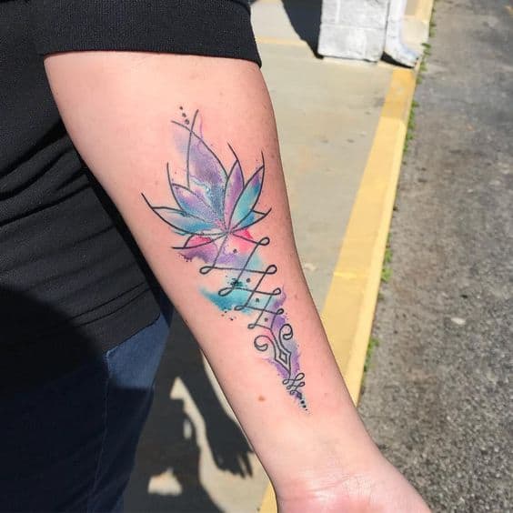 Unalome tattoo with a lotus and vibrant watercolor accents on the forearm, symbolizing spiritual growth, enlightenment, and creativity.