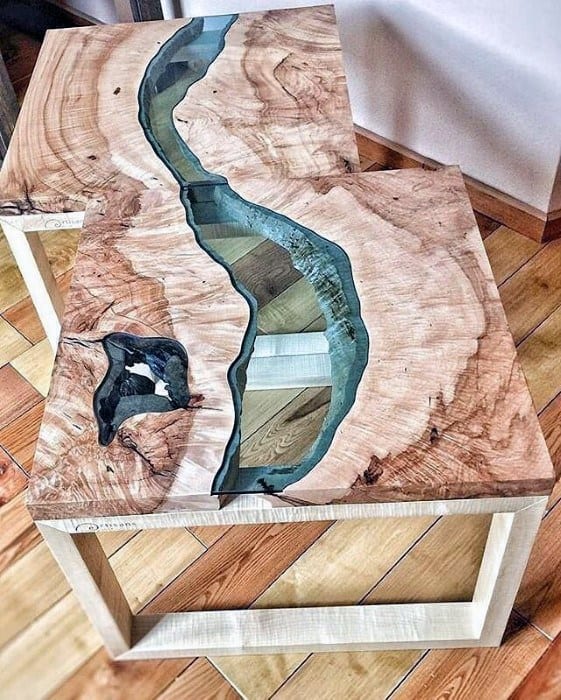 Natural wood coffee tables with river-like blue resin inlays and light wooden legs.