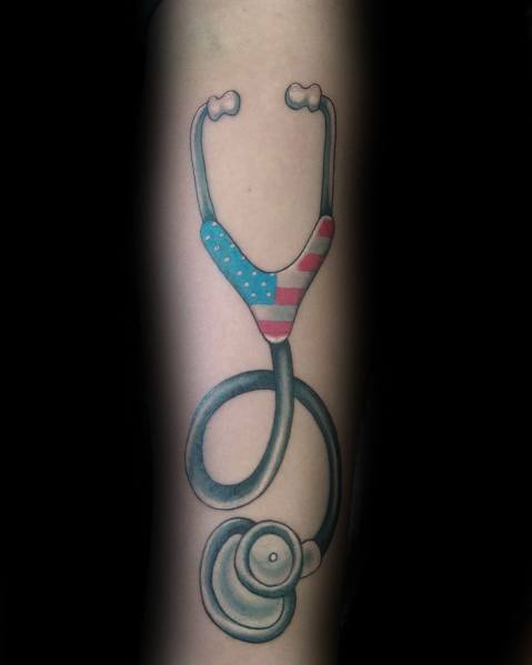 Stethoscope tattoo on the forearm with an American flag design on the chest piece, symbolizing patriotism and dedication to healthcare.
