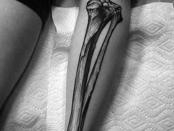 Black and grey anatomical tattoo of forearm bones, featuring realistic shading and fine details for a skeletal illusion effect.