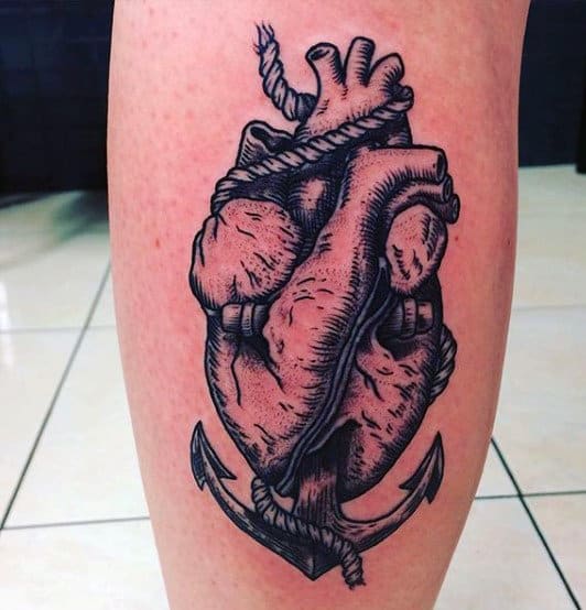 Tattoo of an anatomical heart entwined with a rope and an anchor on a leg