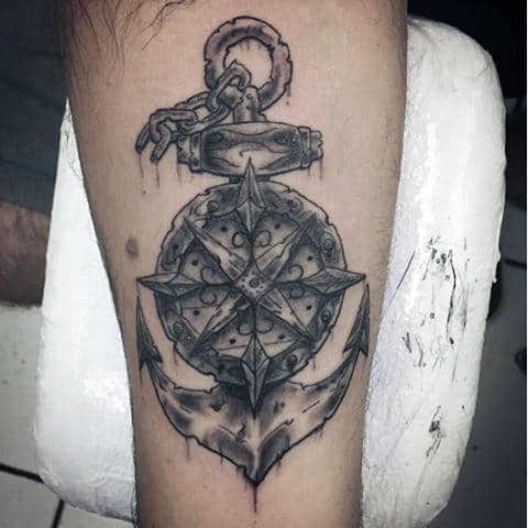 Tattoo of an anchor with a detailed compass design on an arm