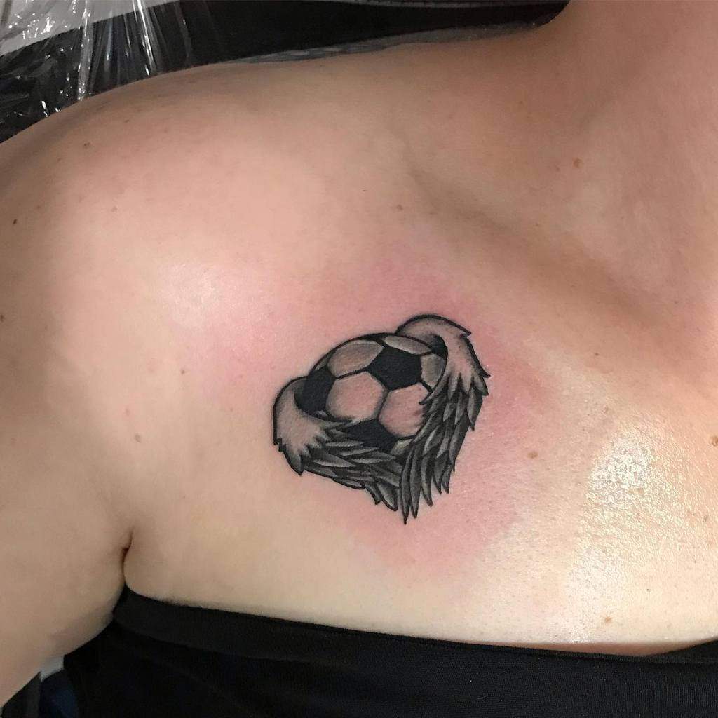 Unique tattoo featuring a soccer ball with angel wings, combining a love for the sport with symbolic wings for freedom and passion