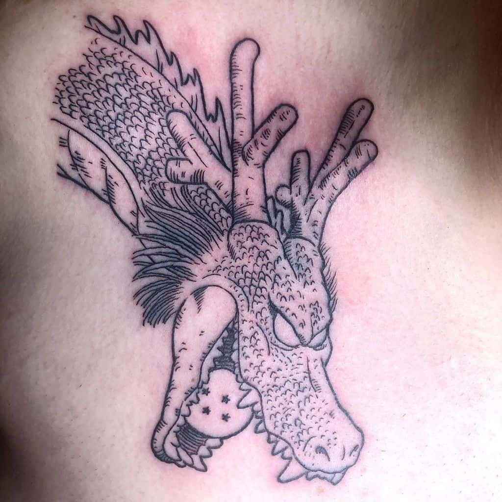 A black line tattoo of Shenron, the mighty dragon from *Dragon Ball*, holding a Dragon Ball in its mouth, surrounded by detailed scales and horns.