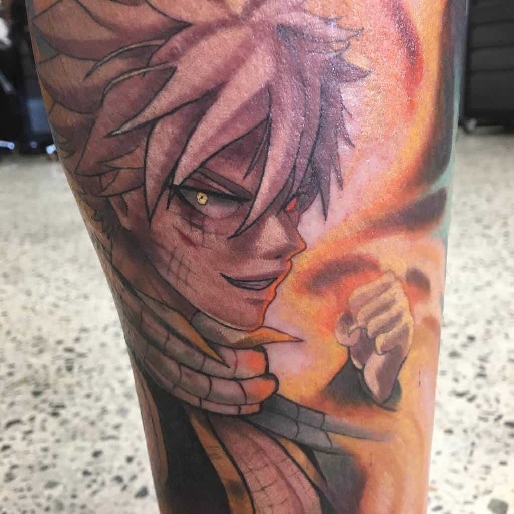 Realistic tattoo of Natsu Dragneel from Fairy Tail, featuring intense shading, fiery colors, and glowing eyes in a dynamic, high-detail design.