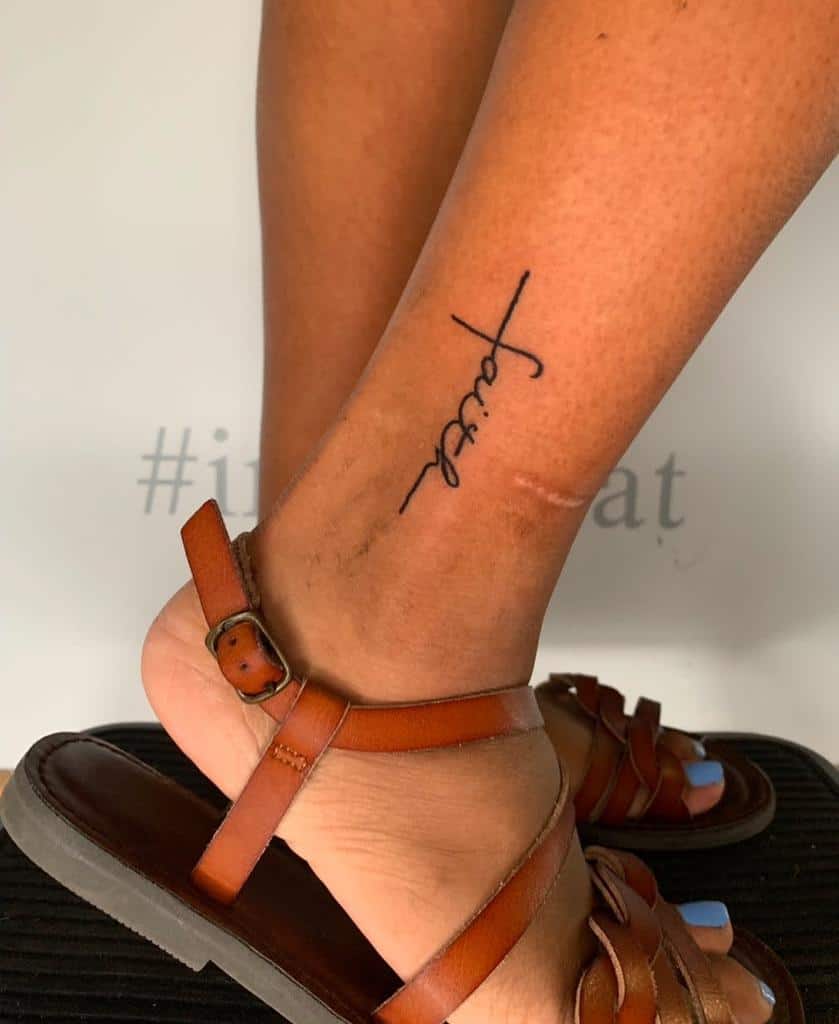 A tattoo of the word "faith" graces a person's ankle, subtly incorporating a cross