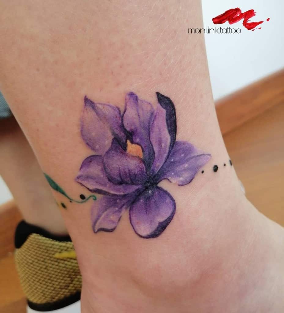 Purple magnolia flower tattoo on ankle with a dotted vine design