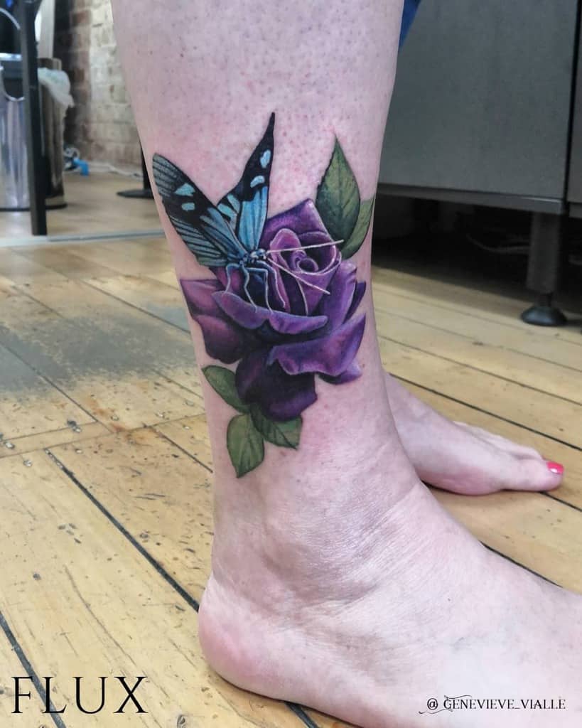 A stunning tattoo of a vibrant purple rose intertwined with a delicate blue butterfly graces the lower leg