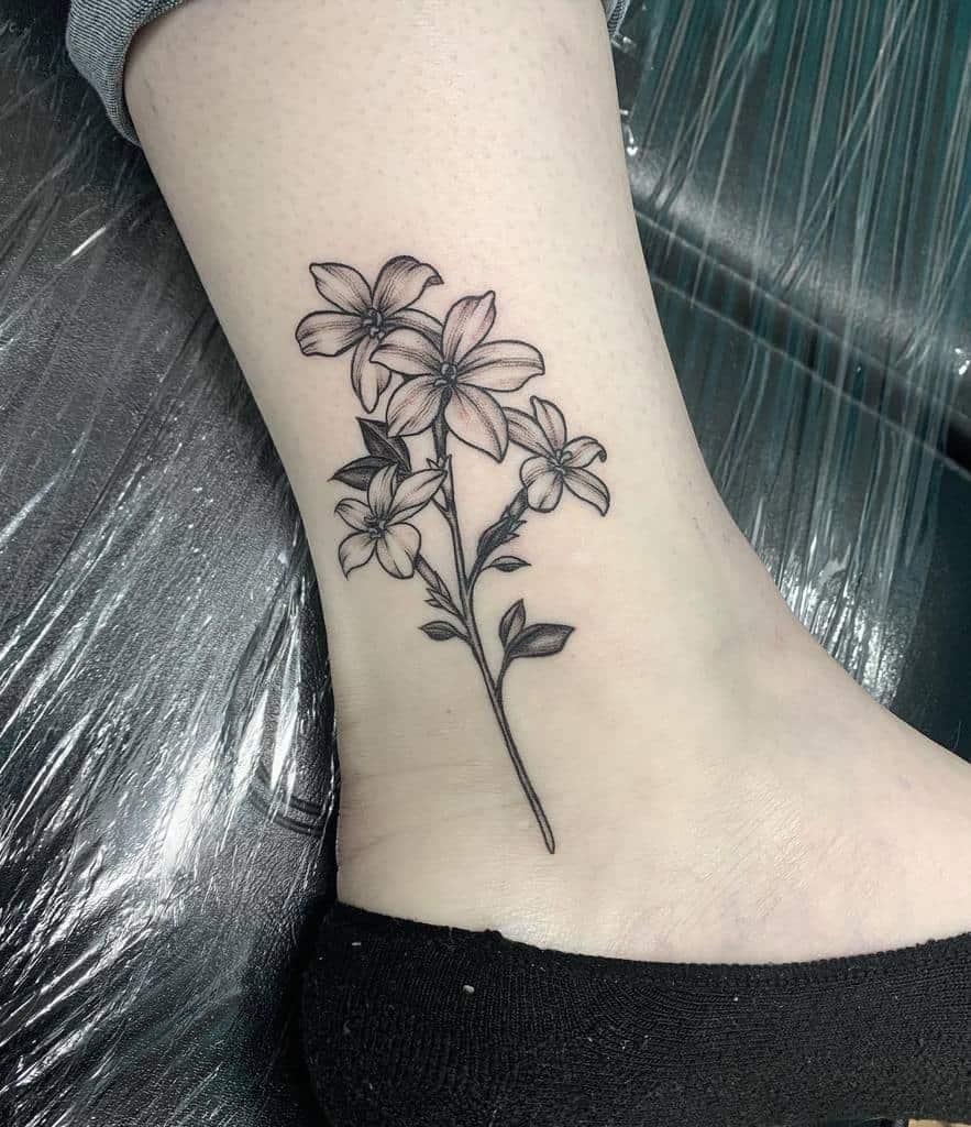 Black and gray floral tattoo on a lower leg