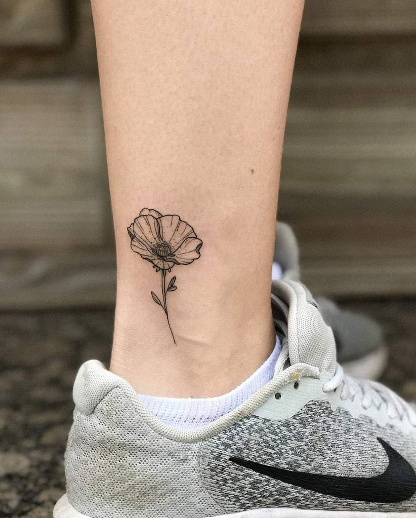 A delicate flower tattoo on an ankle